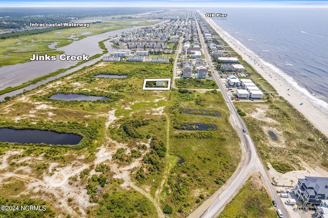 aerial view with a water view and a beach view