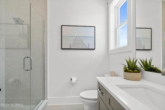 bathroom with a shower with door, vanity, and toilet