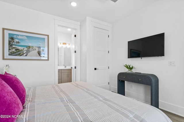 bedroom featuring wood-type flooring, connected bathroom, and sink