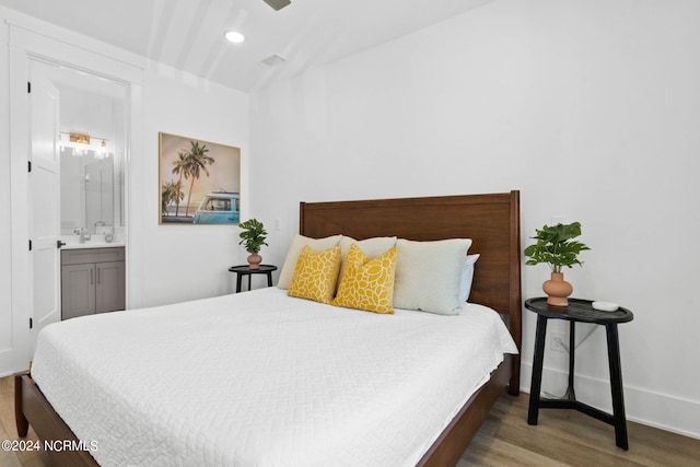 bedroom featuring light wood-type flooring and ensuite bath