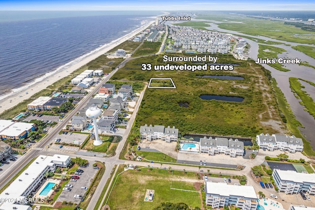 bird's eye view with a water view and a beach view