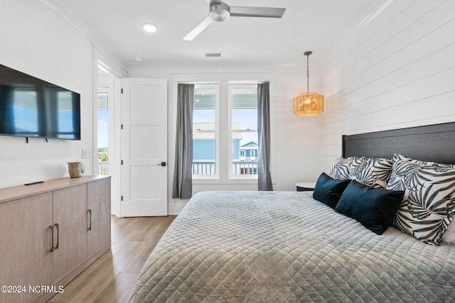 bedroom featuring crown molding, light hardwood / wood-style floors, and ceiling fan