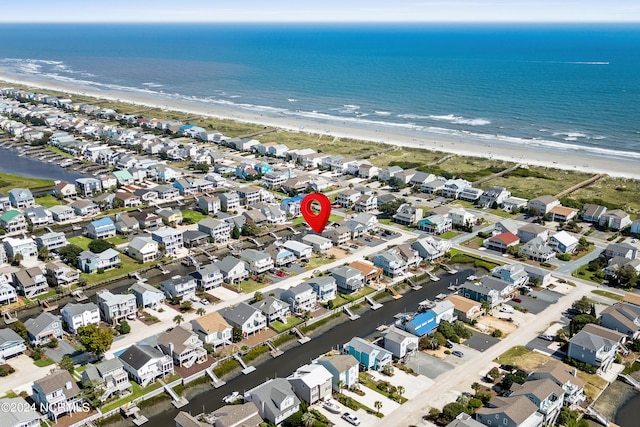 bird's eye view with a water view and a beach view