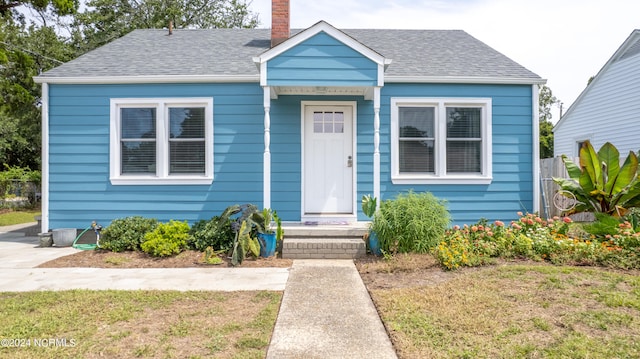 bungalow-style home featuring a front lawn