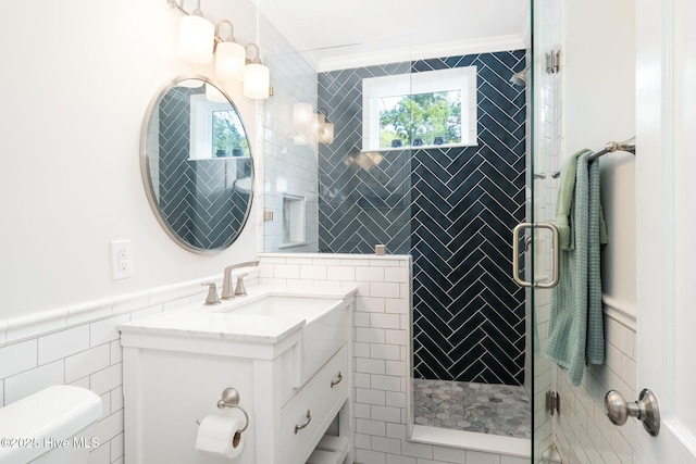 bathroom with tile walls, vanity, ornamental molding, toilet, and walk in shower