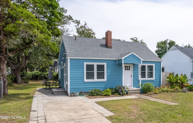 bungalow-style home with a front yard