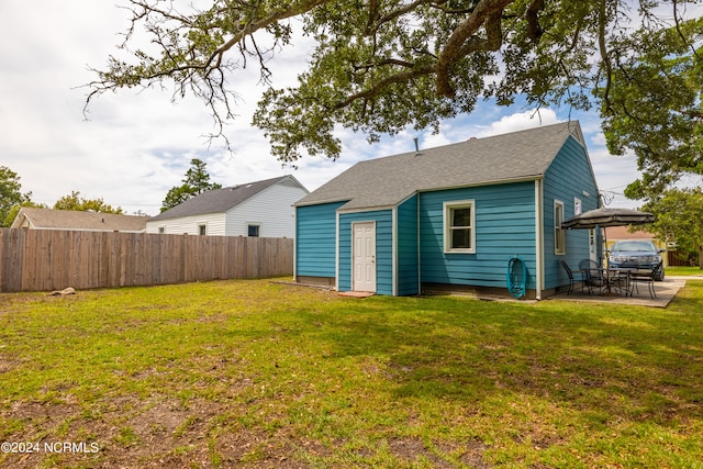 back of house with a patio and a yard