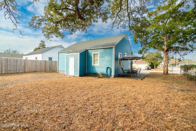 rear view of house featuring an outdoor structure