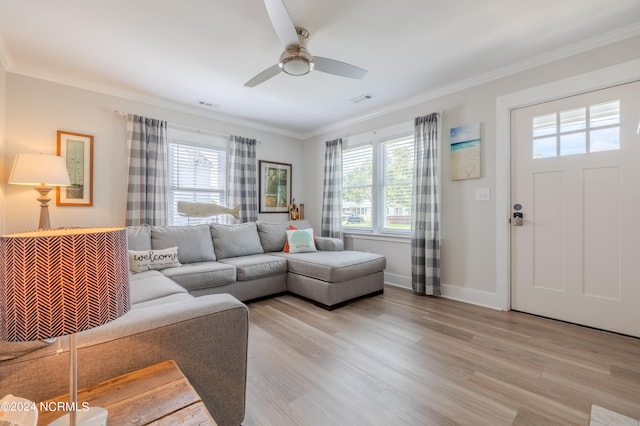 living room featuring light hardwood / wood-style floors, crown molding, ceiling fan, and a healthy amount of sunlight