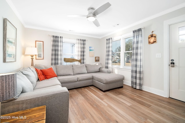 living room with ceiling fan, ornamental molding, and light wood-type flooring