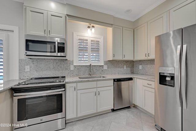 kitchen with backsplash, sink, light stone counters, and appliances with stainless steel finishes