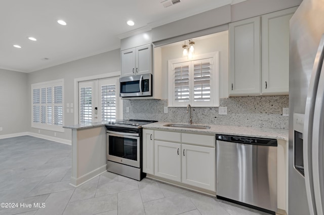 kitchen featuring stainless steel appliances, sink, light stone counters, tasteful backsplash, and white cabinets