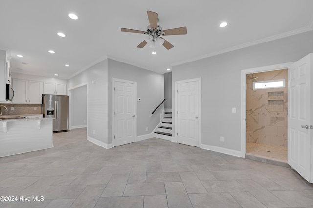 unfurnished living room with ornamental molding, sink, ceiling fan, and light tile patterned flooring