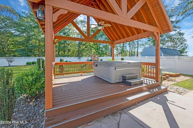 wooden deck featuring a hot tub, a gazebo, and ceiling fan