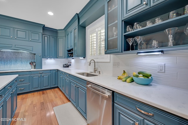 kitchen featuring stainless steel dishwasher, blue cabinetry, sink, and light wood-type flooring