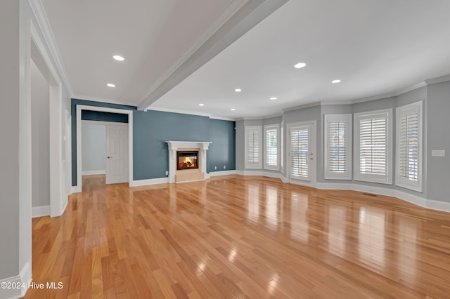 unfurnished living room with crown molding and light hardwood / wood-style flooring