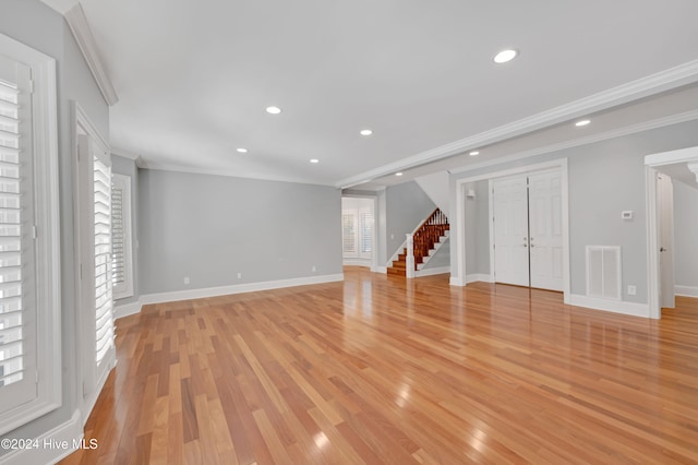 unfurnished living room with light hardwood / wood-style floors and crown molding