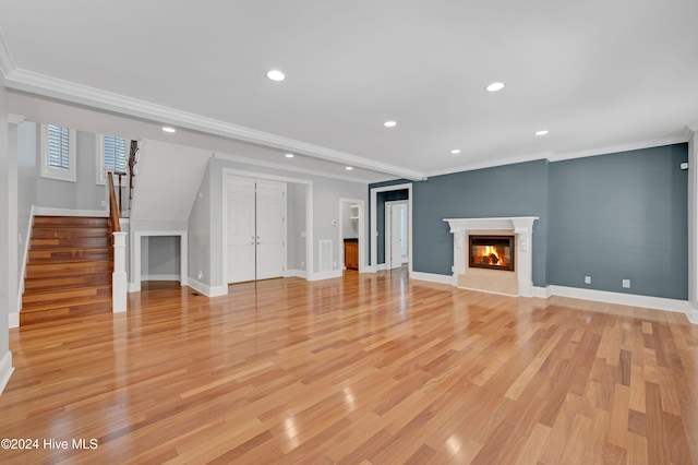 unfurnished living room with light hardwood / wood-style floors and crown molding