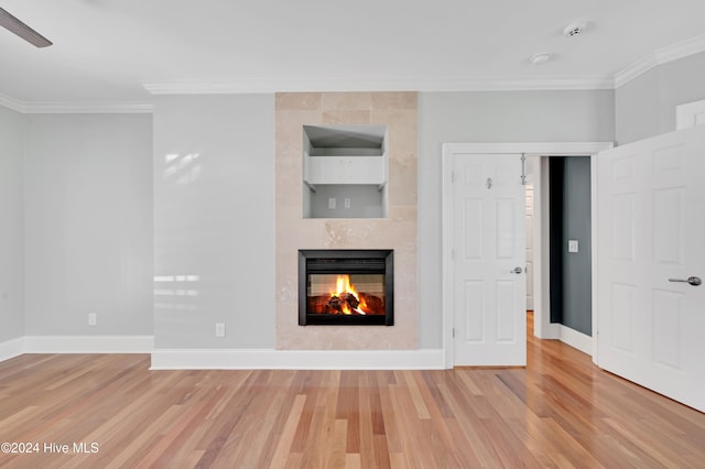 unfurnished living room featuring hardwood / wood-style floors, a fireplace, and crown molding