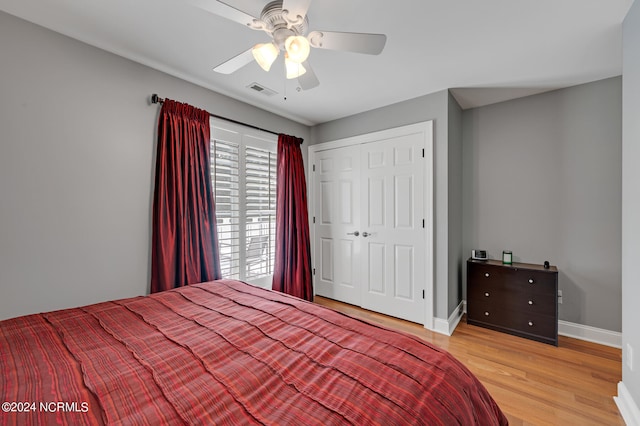 bedroom featuring light wood-type flooring, ceiling fan, and a closet