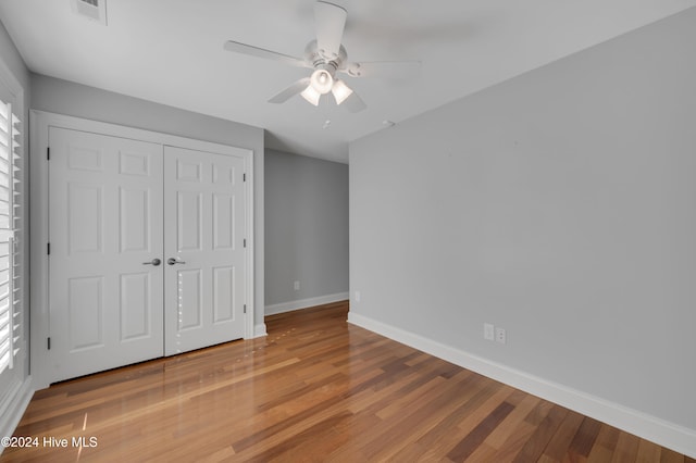 unfurnished bedroom featuring hardwood / wood-style flooring, ceiling fan, and a closet