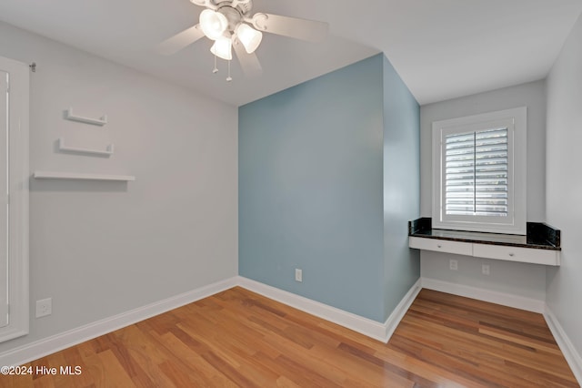 empty room with light wood-type flooring and ceiling fan