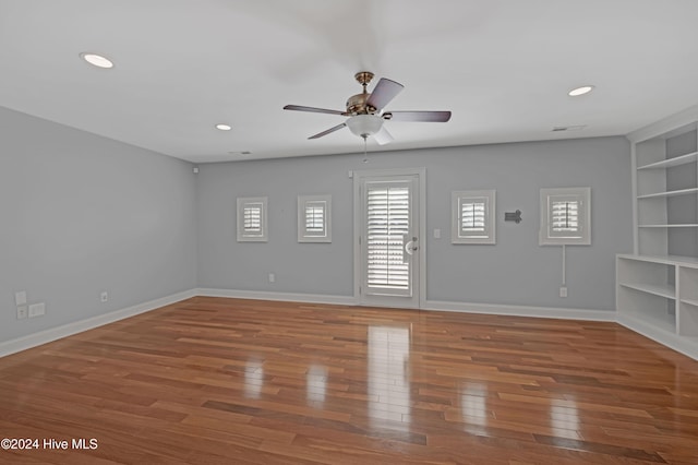 unfurnished room featuring hardwood / wood-style flooring, ceiling fan, and built in features