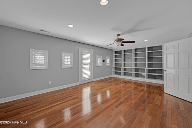 interior space with hardwood / wood-style floors, ceiling fan, and built in shelves