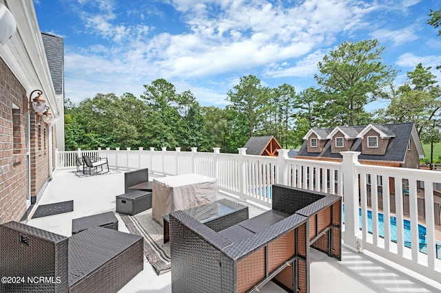 wooden deck featuring an outdoor living space, a fenced in pool, and a patio area