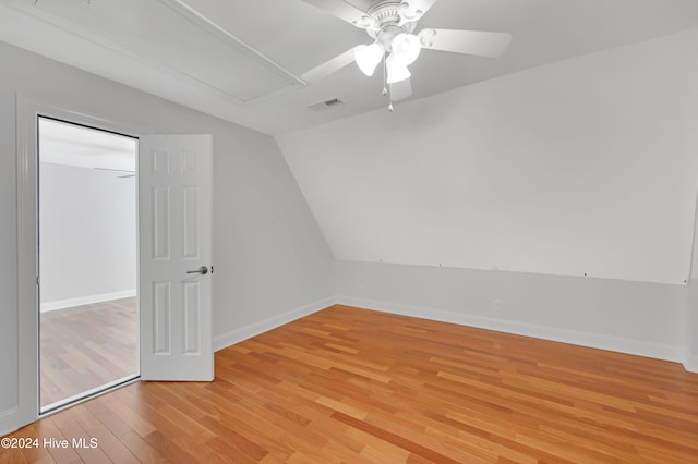 empty room featuring ceiling fan, light wood-type flooring, and vaulted ceiling