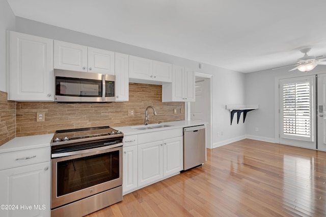 kitchen featuring white cabinetry, light wood-type flooring, appliances with stainless steel finishes, and sink