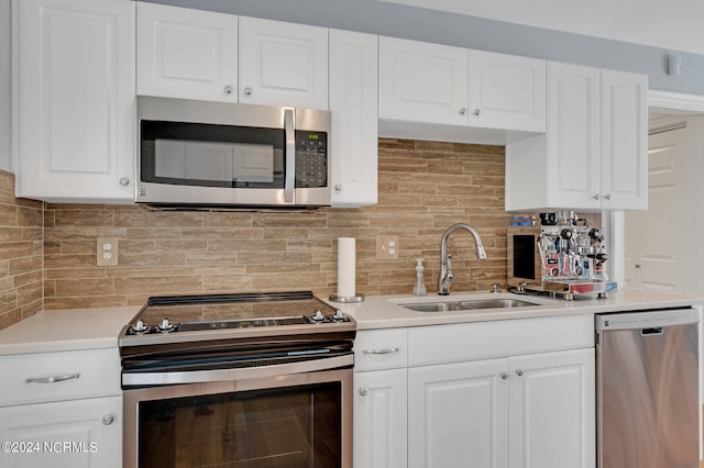 kitchen featuring white cabinetry, decorative backsplash, stainless steel appliances, and sink