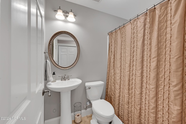 bathroom featuring a shower with shower curtain and toilet