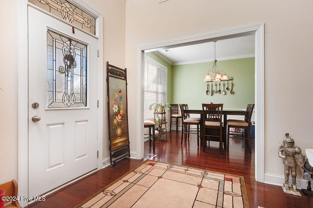 entryway with crown molding, wood-type flooring, and a notable chandelier