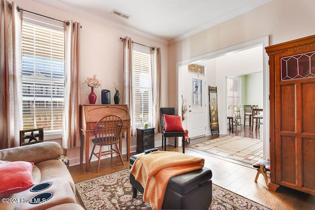 sitting room featuring ornamental molding, light hardwood / wood-style flooring, and a healthy amount of sunlight