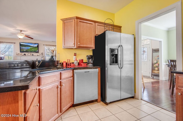 kitchen with appliances with stainless steel finishes, ornamental molding, ceiling fan, sink, and light hardwood / wood-style floors