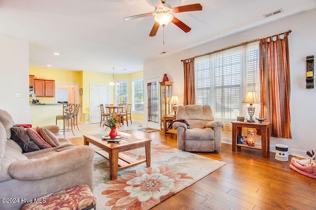 living room featuring wood-type flooring and ceiling fan