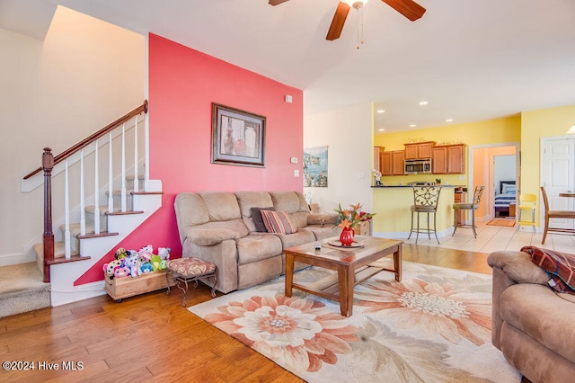 living room featuring light hardwood / wood-style flooring and ceiling fan