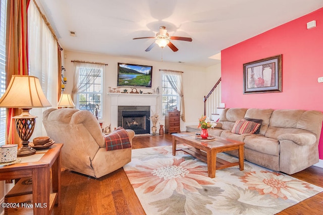 living room featuring ceiling fan, wood-type flooring, and a wealth of natural light