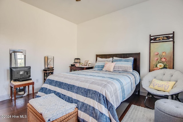 bedroom with dark hardwood / wood-style floors