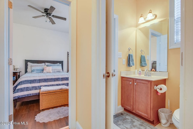 bedroom with ceiling fan, light hardwood / wood-style flooring, and sink