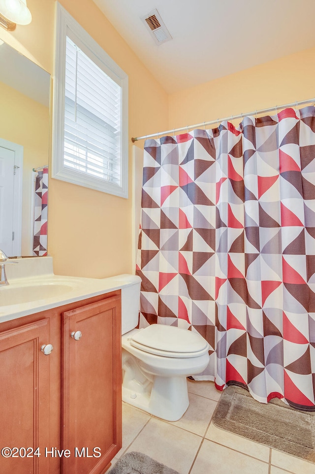 bathroom with tile patterned flooring, vanity, and toilet