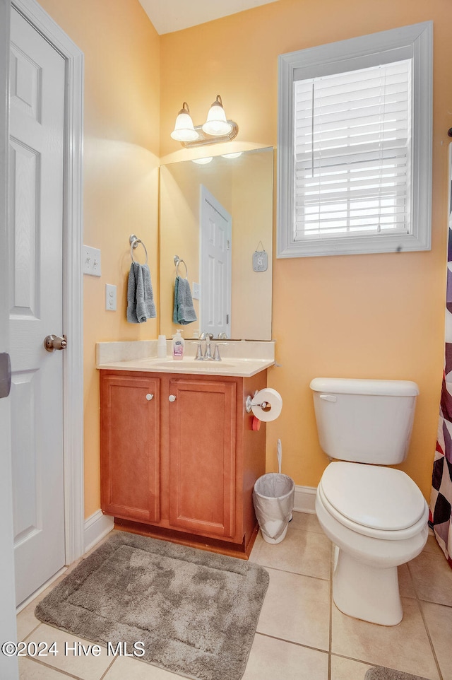 bathroom with tile patterned flooring, vanity, and toilet