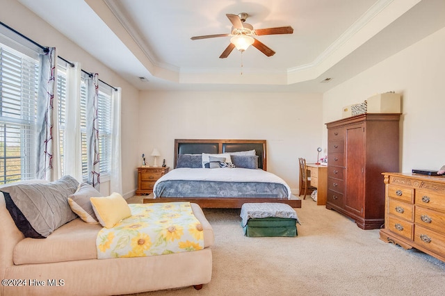 carpeted bedroom featuring a tray ceiling, ceiling fan, and crown molding