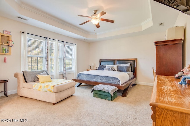 bedroom featuring ornamental molding, a tray ceiling, ceiling fan, and light colored carpet