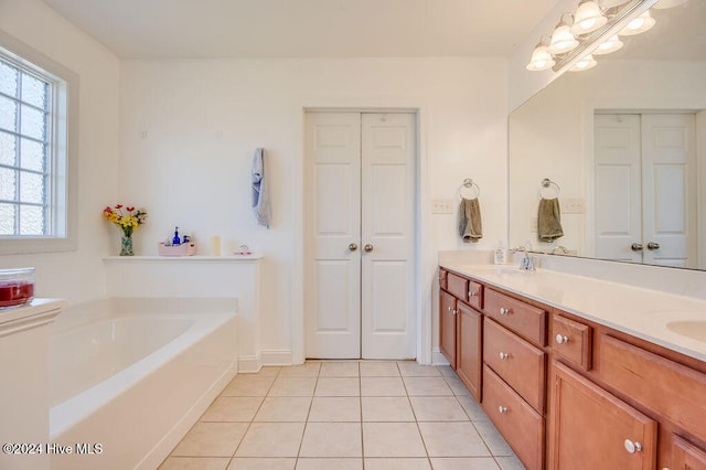 bathroom with tile patterned flooring, vanity, and a bath