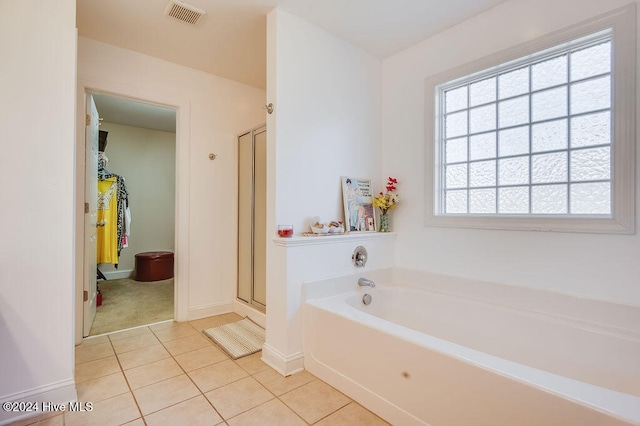 bathroom with tile patterned flooring and shower with separate bathtub