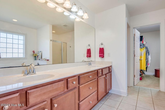 bathroom featuring tile patterned flooring, vanity, and a shower with shower door