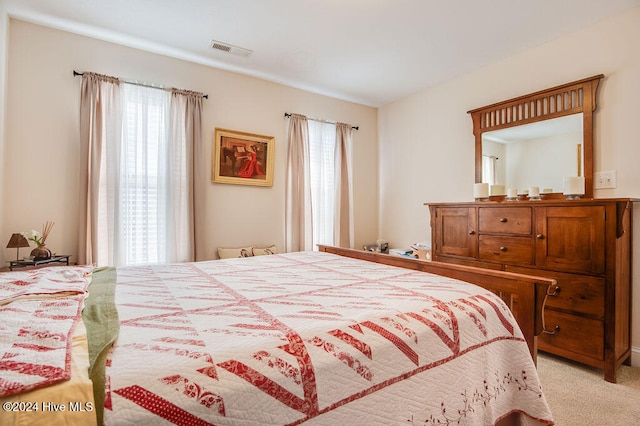 bedroom with light carpet and multiple windows