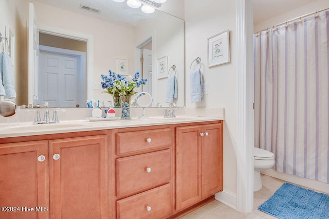 bathroom featuring tile patterned flooring, vanity, and toilet